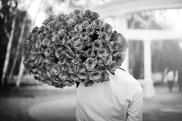 バラの屋外の大きな花束を持つ男 — ストック写真