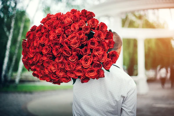 Man with big bouquet of roses — Stock Photo, Image