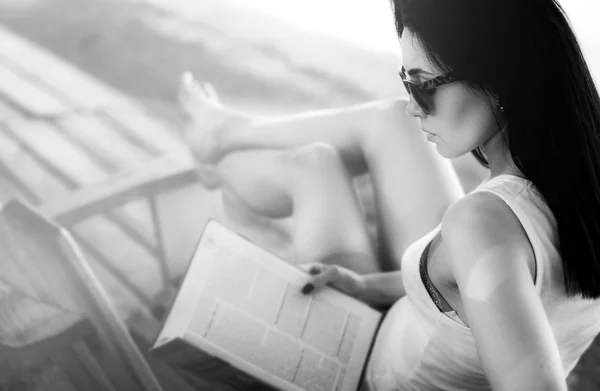 Дівчина читає книгу на відкритому повітрі на пляжі — стокове фото