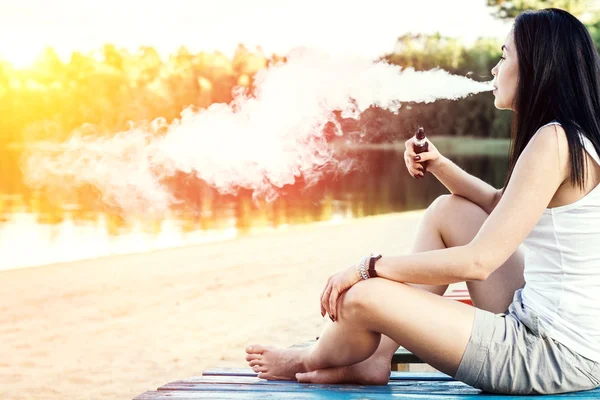 Дівчина курить електронну сигарету — стокове фото