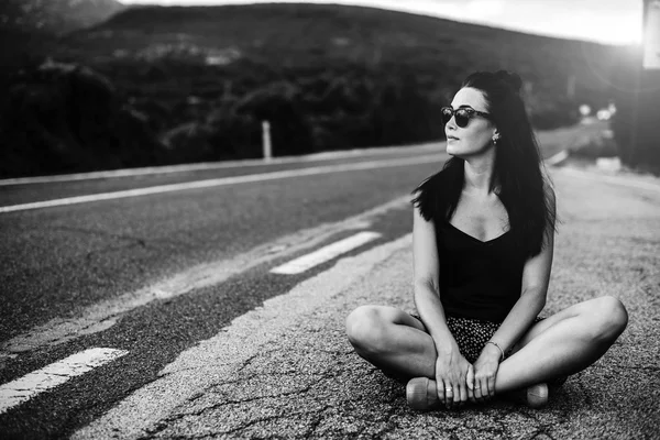 Menina turística bonita sentada na estrada — Fotografia de Stock