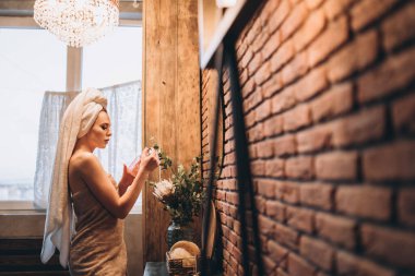 Üzerinde havlu olan güzel esmer kadın banyodan çıktıktan sonra aynanın yanında duruyordu.