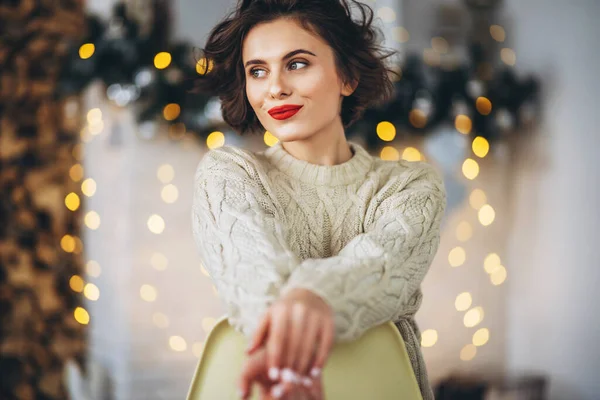 Bonita Feliz Morena Sentada Suéter Caliente Silla Con Luces Navidad — Foto de Stock