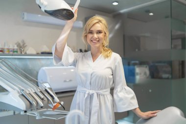 Modern diş muayenehanesinde gülümseyen genç bir dişçinin portresi.. 