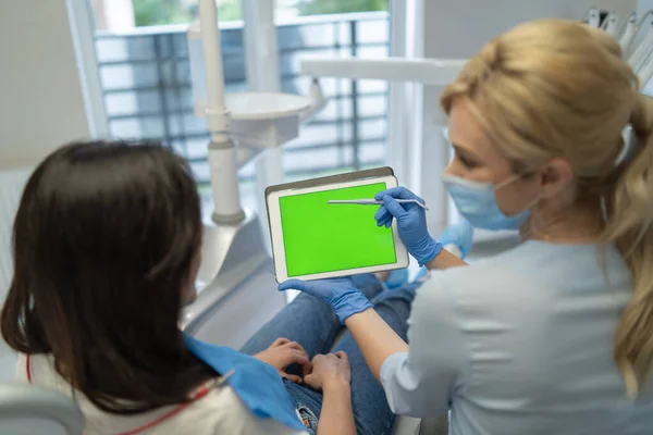Zahnärztin Zeigt Patientin Einen Tablet Mit Behandlungsinformationen Mit Chromakey Auf — Stockfoto
