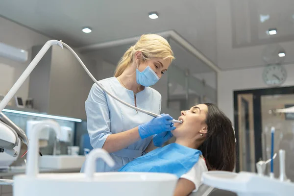 歯科医院の女性歯科医は 女性患者の口腔の検査と治療を提供しています — ストック写真