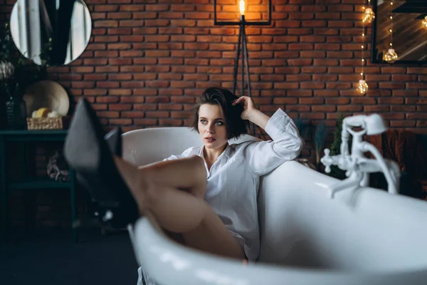 Güzel Bir Esmerin Portresi Boş Bir Banyoda Uzanmış Bacakları Havada — Stok fotoğraf