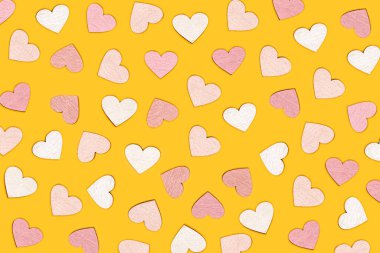 Parlak sarı arka planda kalp şeklindeki nesnelerin yaratıcı düzlüğü. Aşk konsepti