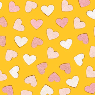 Parlak sarı arka planda kalp şeklindeki nesnelerin yaratıcı düzlüğü. Aşk konsepti