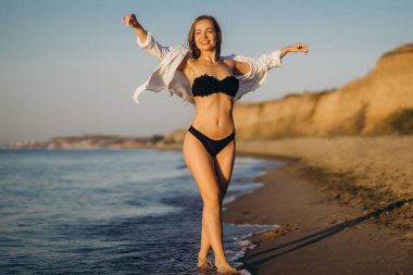 Güzel esmer kadın denizin sahilinde dinleniyor.