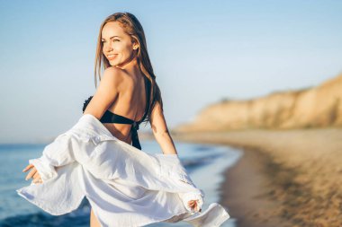 Güzel esmer kadın denizin sahilinde dinleniyor.