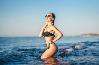 Güzel esmer kadın denizin sahilinde dinleniyor.