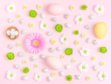 Pastel arka planda çiçeklerin ve paskalya yumurtalarının yaratıcı yerleşimi