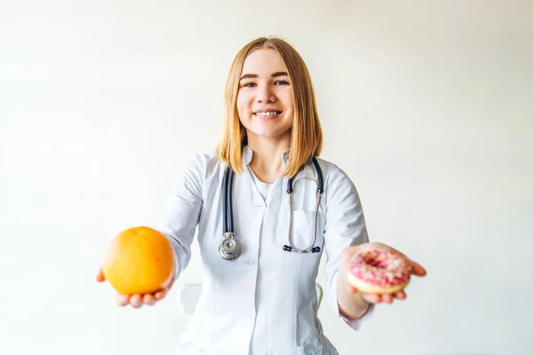 Διατροφολόγος Γυναίκα Γιατρός Κρατώντας Πορτοκάλι Και Ντόνατ Στα Χέρια Δίαιτα — Φωτογραφία Αρχείου