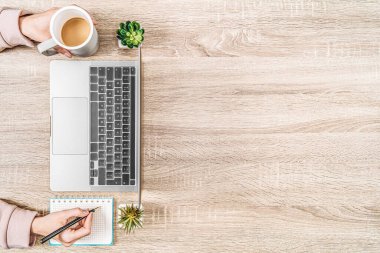 Dizüstü bilgisayarı olan iş yeri manzarası, kahve ve not defteri olan eller