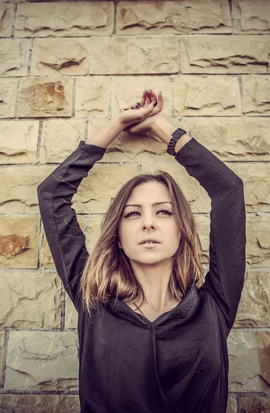 Joven señora bastante elegante posando cerca de la pared de luz urbana en vintag — Foto de Stock