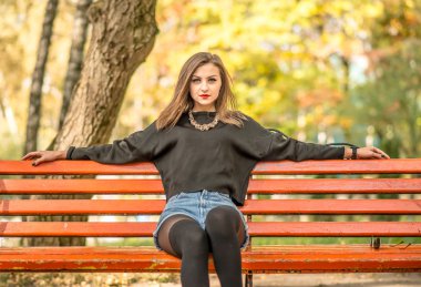 Parkta bankta oturan genç güzel kız