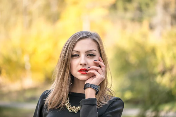 Retrato de una joven dama bastante elegante posando cerca de colorido tre — Foto de Stock