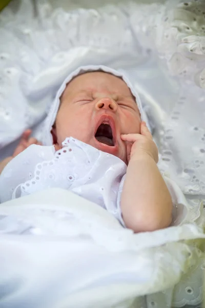 Μικρό νεογέννητο κοιμάται πάνω από το λευκό κρεβάτι σε άσπρο φόντο — Φωτογραφία Αρχείου