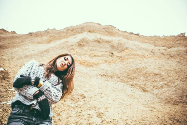 Mooie jonge vrouw buiten in steengroeve met zand — Stockfoto