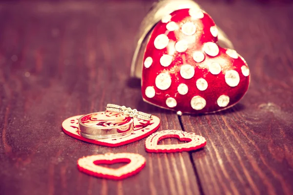 Decoration with red hearts and wedding rings on the wooden backg — Stock Photo, Image