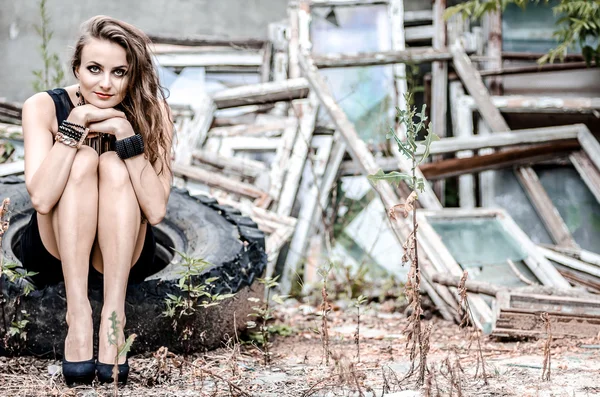 Girl sitting on the truck wheel — Stock Photo, Image