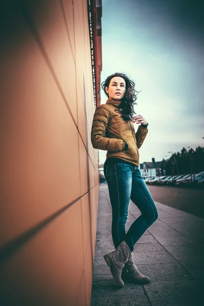 Девушка на городской улице возле стены — стоковое фото
