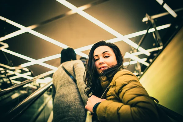 Chica en la escalera mecánica en el centro comercial — Foto de Stock