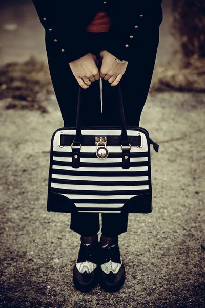 Girl with black and white bag in the hands — Stock Photo, Image
