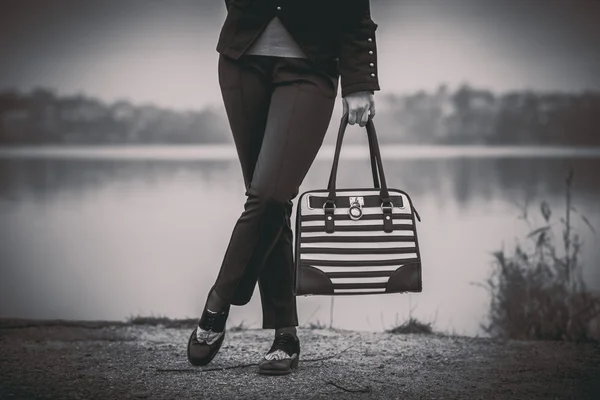 Menina com saco preto e branco nas mãos — Fotografia de Stock