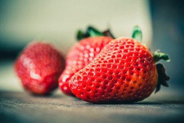 Ahşap arka plan üzerinde kırmızı çilek makro çekim