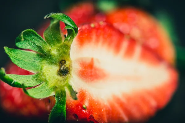 Macro shot of red sliced strawberry on wooden background — Stock Photo, Image