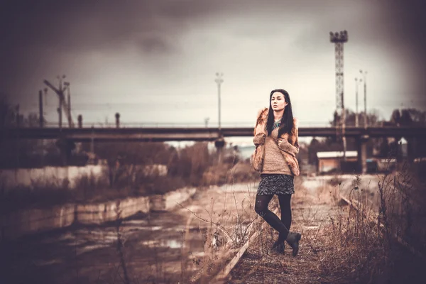 Cheveux longs brunette fille en plein air avec vieux pont industriel behin — Photo