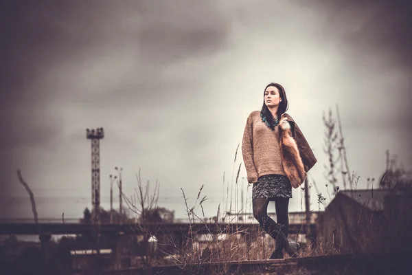 Cheveux longs brunette fille en plein air avec vieux pont industriel behin — Photo