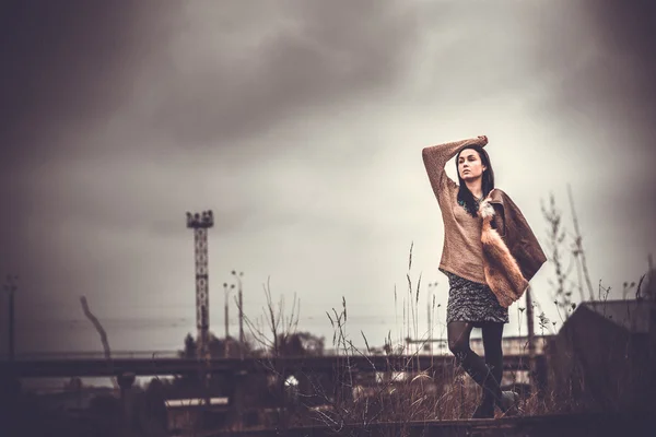 Cheveux longs brunette fille en plein air avec vieux pont industriel behin — Photo