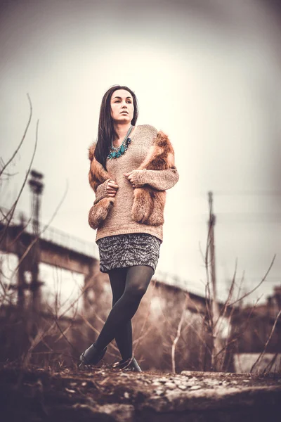 Long hair brunette girl outdoor with old industrial bridge behin — Stock Photo, Image