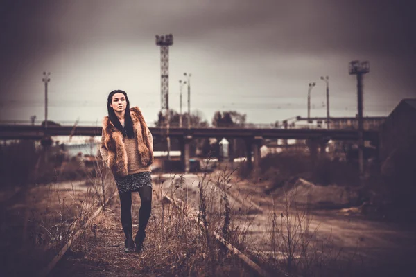 Långt hår brunett tjej utomhus med gamla industriella Visa bakom, — Stockfoto
