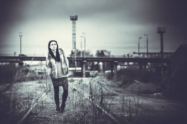 Pretty long hair brunette girl with old industrial bridge behind, black and white