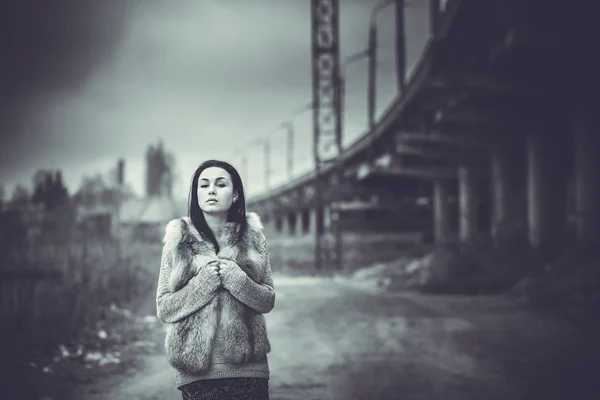 Long hair brunette girl outdoor with old industrial bridge behin — Stock Photo, Image