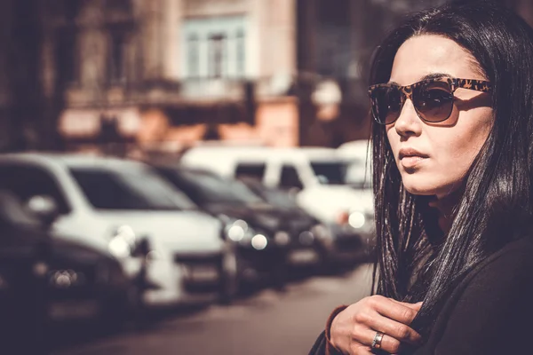 长长的头发黑发女孩户外与城市街道上背景 — 图库照片