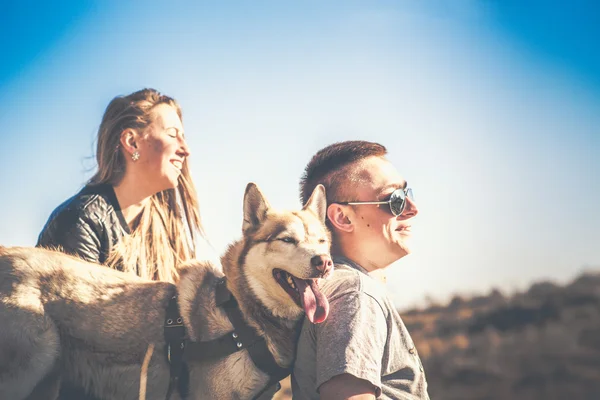 Romantický pár odpočinku venkovní v lese s husky — Stock fotografie