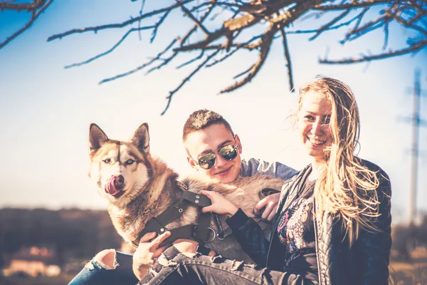 Romantický pár odpočinku venkovní v lese s husky — Stock fotografie