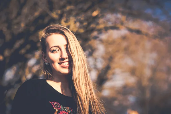 Jong meisje zitten buiten in het park — Stockfoto