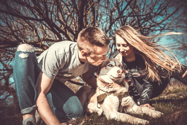 Casal bonito descansar ao ar livre na floresta com husky — Fotografia de Stock