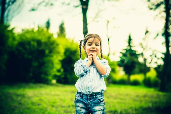 Щаслива маленька красива дівчинка на відкритому повітрі в парку — стокове фото