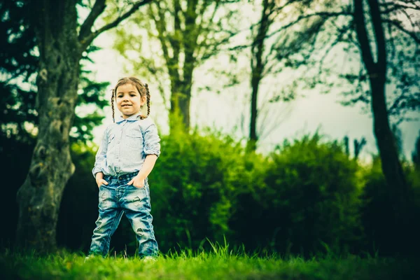 Glad lilla vackra flicka utomhus i parken — Stockfoto