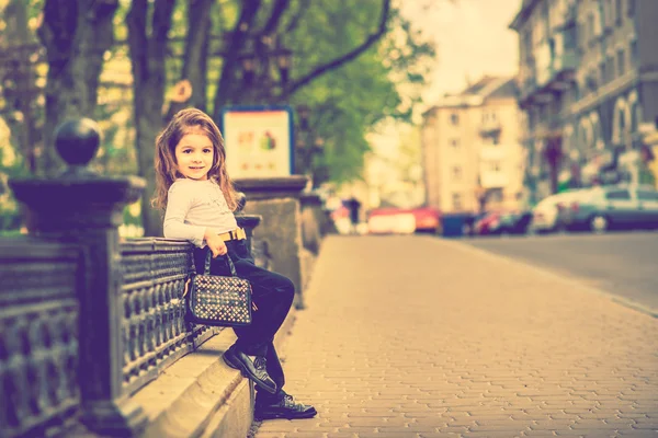 Petite jolie fille marchant dans la rue de la ville — Photo