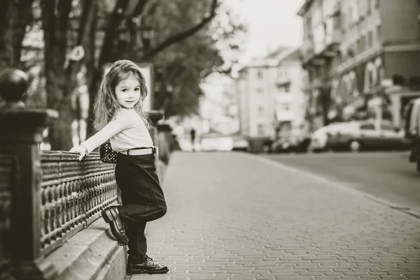 Petite jolie fille marchant dans la rue de la ville — Photo