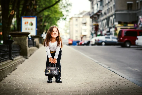 Petite jolie fille marchant dans la rue de la ville — Photo