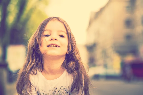 Маленькая красивая девочка, идущая по городской улице — стоковое фото